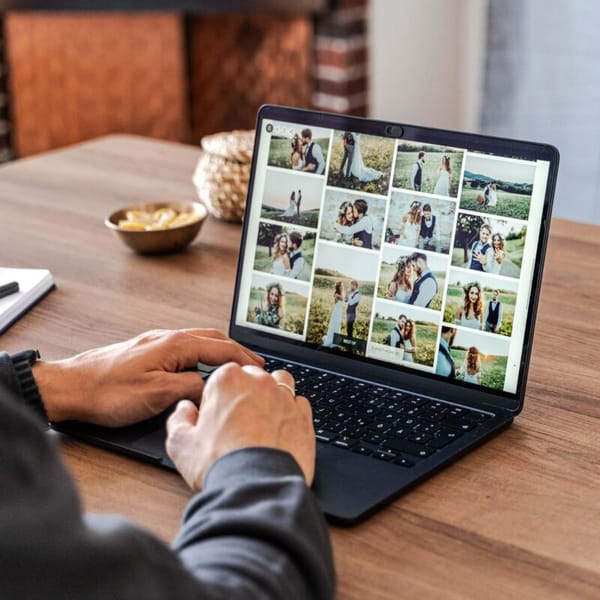 A photographer looking at their laptop screen at the photos and videos in the gallery they created. Doing a last check before delivering it to their clients.