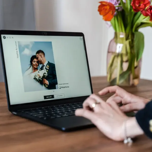 Ein zufriedener Kunde, der auf seinem Laptop die Galerie betrachtet, die sein Fotograf geliefert hat